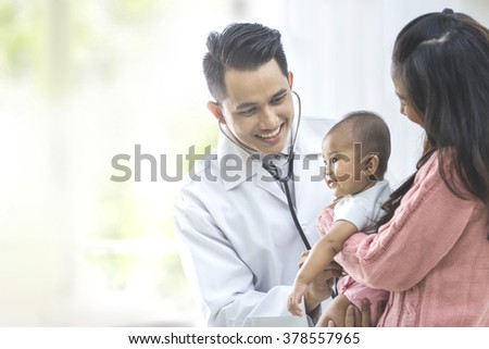 portrait of a baby being checked by a doctor using a stethoscope Royalty-Free Stock Photo #378557965