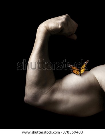 Butterfly Resting on Man Flexing Bicep Muscle on a Black Background