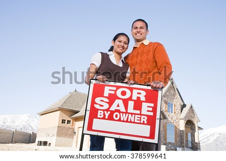 Portrait of a couple hold a for sale sign