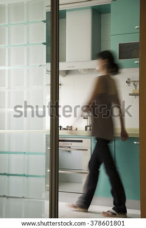 Young woman walking in a kitchen