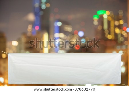 Copy space for text on long white vinyl banner on Blur night city background .Clipping path