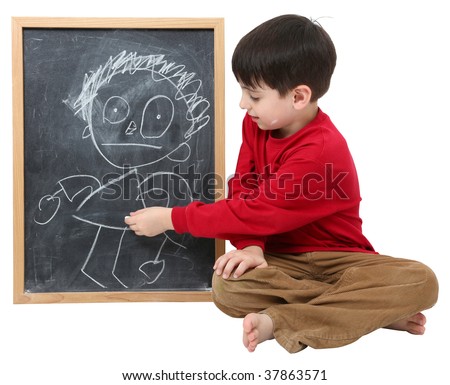Adorable six year old school boy with drawing on chalkboard with clipping path over white.