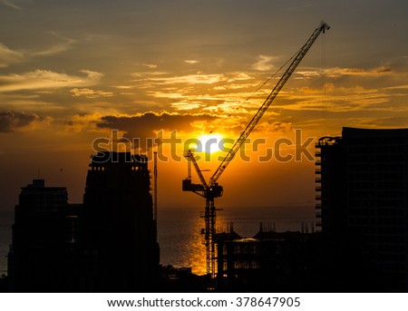 Silhouette of construction site next to the sea in the evening.