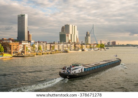 Rotterdam City, Erasmus Bridge, Container Ship (Cargo Ship) of harbor cruise Rotte river and Aerial View Cityscape Panorama Skyline under Dramatic Golden Sky Sunset Summer, Netherlands