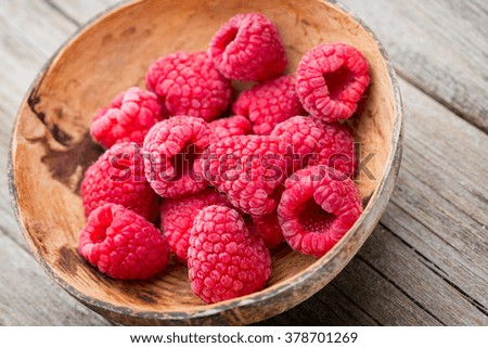 Frozen raspberries on wooden background.
