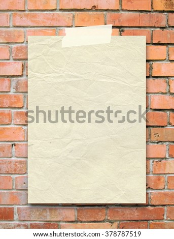 Close-up of one hanged old vintage paper sheet with adhesive tape on orange brick wall background