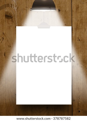 Close-up of one hanged paper sheet frame with clip on brown wooden boards background