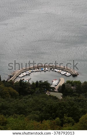 Sorrento. Italy - Month 09.2015: Gorgeous top view from green hill on amazing curve pier in tyrrhenian sea with many white yachts italian coast outdoor, vertical picture