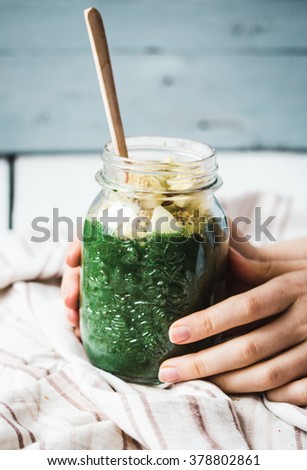 green smoothie with apples, pears, spinach and spirulina, detox drink in bank mason jar, hands Royalty-Free Stock Photo #378802861