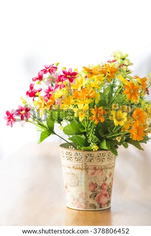 Bunch of artificial flowers on wood background