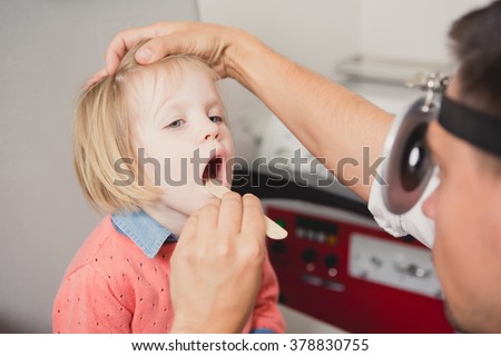 Doctor ENT checking ear with otoscope to girl patient 