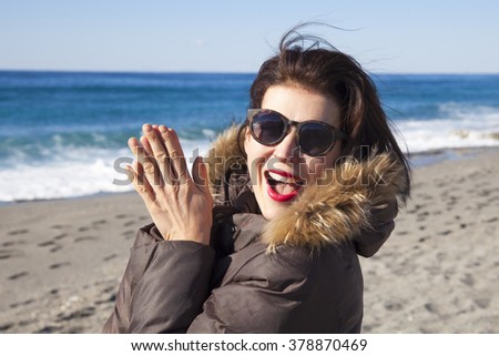 Woman walking along the beach in winter.