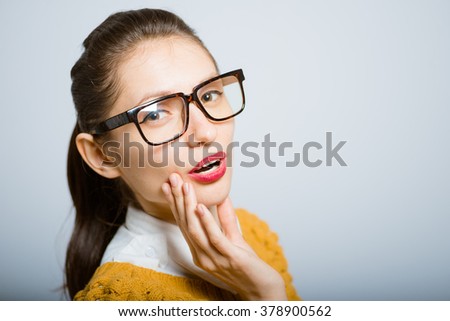Girl flirts, hipster glasses isolated on a gray background