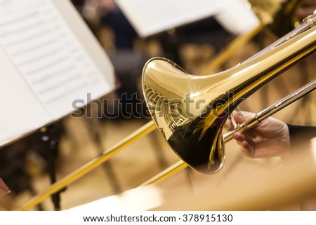 Detail of a trombone in the hands of the musician closeup Royalty-Free Stock Photo #378915130