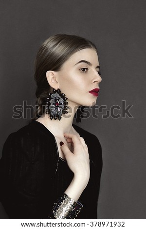 Portrait of young beauty dark hair girl in vintage style dress with beautiful hair and big earrings