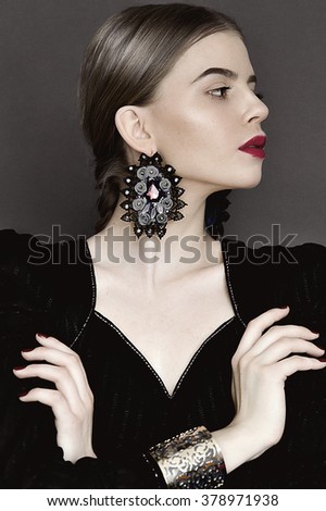 Portrait of young beauty dark hair girl in vintage style dress with beautiful hair and big earrings