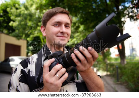 young man with a professional camera in the hands of the street
