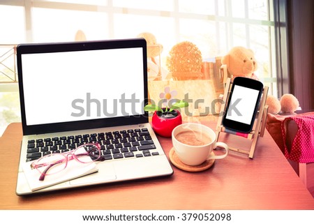 laptop and coffee with blur image of toy decoration in coffee shop background