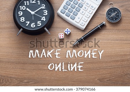 make online money written on wooden table with clock,dice,calculator pen and compass