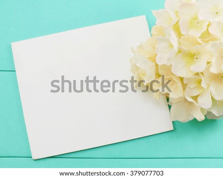 white card and artificial flower valentines day on green background