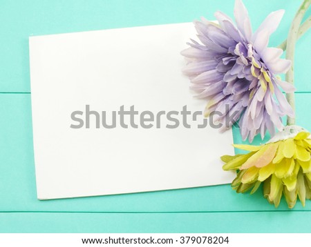 white card and artificial gerbera flower valentines day on green background