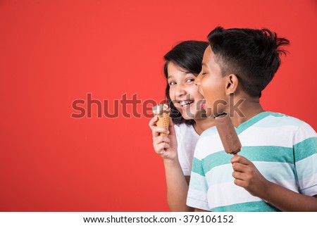 Indian/Asian cute kids eating Ice cream in cone or candy. Isolated over colourful background