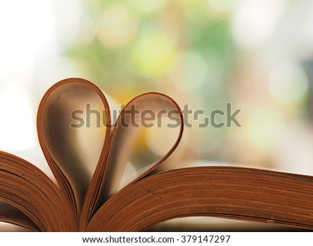 Old book page decorate to heart shape for love in valentine day with blurred background and vintage color tone style. Composition of love with open book heart.