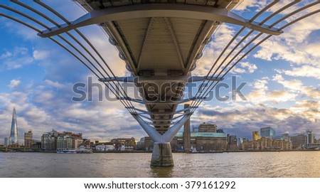 Panoramic skyline taken under the Millennium Bridge at sunset with beautiful sky and clouds - London, UK