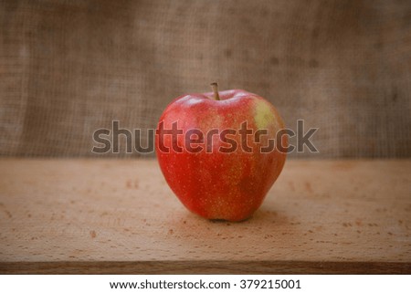 Healthy lifestyle. Apple yogurt diet. Red ripe apples and a transparent cup of yogurt on a wooden table on a light brown background. cut apple with seeds