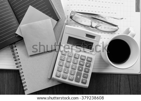 calculator and planner on the wooden table with black and white color concept