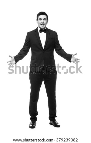 Cheerful young man in suit shocked sign and smiling while standing against white background.Showman concept.