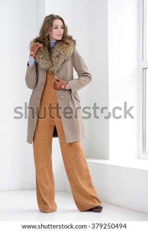 Young girl in studio posing at coat