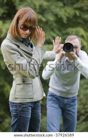 paparazzo takes a picture from a woman on the street