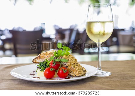 Seared salmon fillet with wine on restaurant background Royalty-Free Stock Photo #379285723