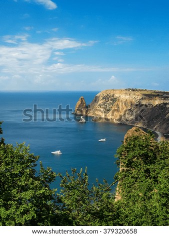 Fiolent, Crimea - cape on the Black Sea, the marine landscape. 
Seascape on a sunny day - the bay, cliffs and white yacht. Beautiful seascape - white yacht in a quiet bay.
