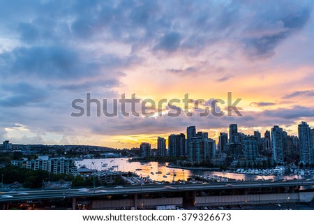view of the buildings of vancouver city skyline and a marina during a beautiful sunset