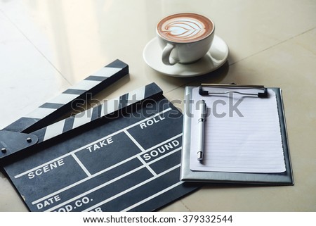 Movie clapper notepad and coffee of cup on office table.vintage effect
