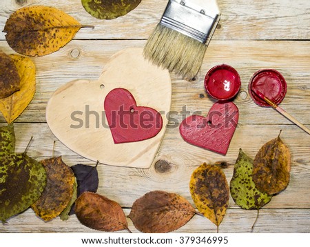 Colorful heart and autumn leaves on a wooden background