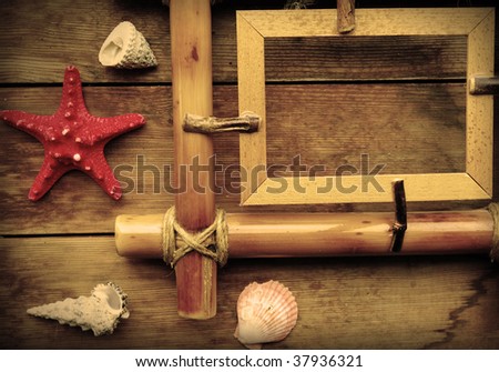 Photo frame, starfish and seashells on wooden background.