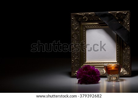 golden mourning frame with flower and candle on dark background