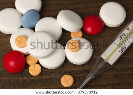 vitamins pills , thermometer macro top view on a table