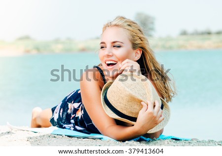 Young smiling woman with hat on the beach