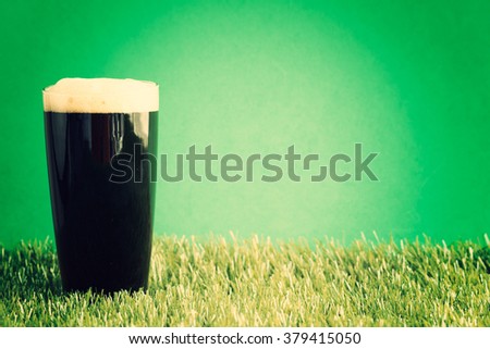 St. Patrick's Day Beer glass over grass and green background