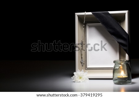 clear mourning frame with flower and candle on dark background