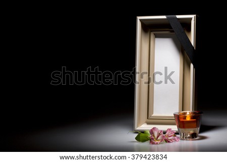 natural wooden mourning frame with flower and candle on dark background