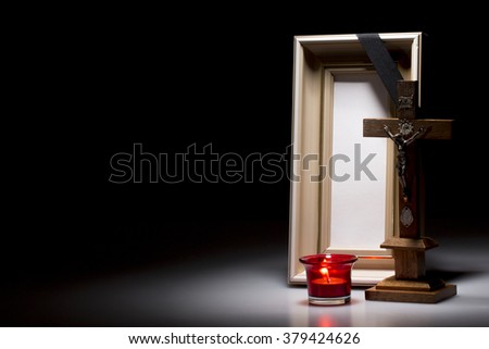 natural wooden mourning frame with candle and crucifix on dark background