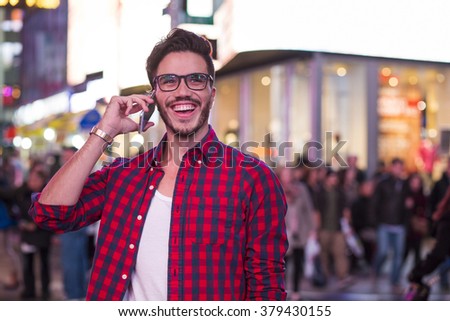 Man making a phone call on Times Square, New York, at night.