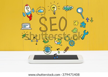 SEO concept with smartphone on yellow wooden background