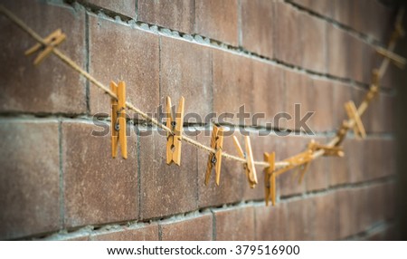 clothes line for hanging photos against a grungy brick wall
