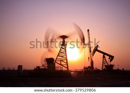 Crank balanced beam pumping unit in Jidong oilfield sunset scenery, Hebei Province, China 
